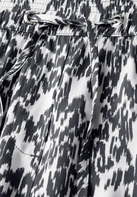 Nahaufnahme einer Hose mit schwarz-weißem Muster und Kordelzug.